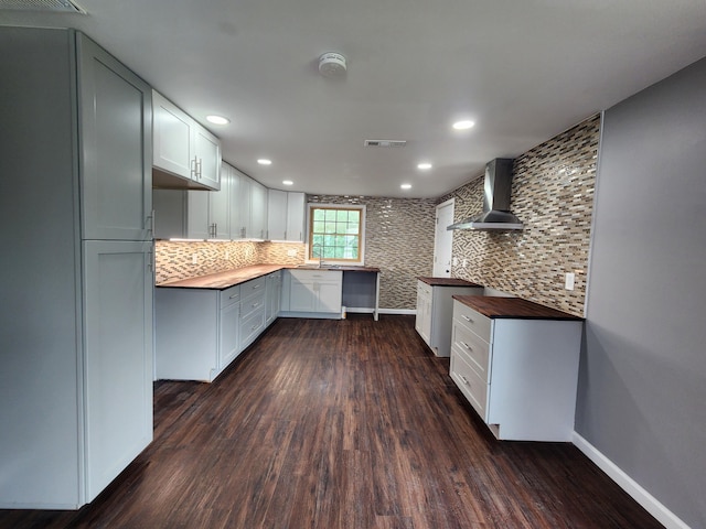 kitchen with visible vents, refrigerator, wall chimney exhaust hood, and dark wood finished floors