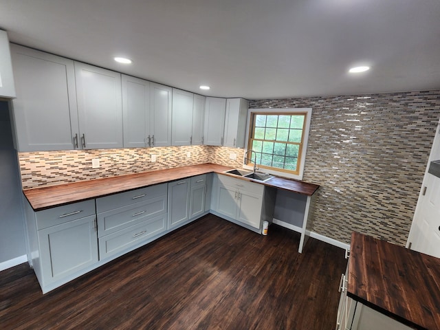 kitchen with dark wood-style floors, backsplash, wooden counters, and a sink