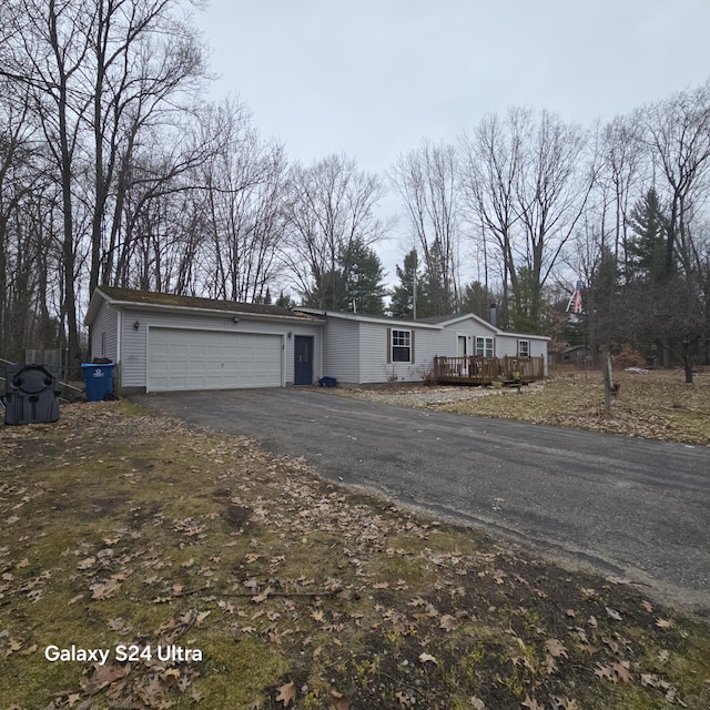 view of front facade with an attached garage, driveway, and a deck