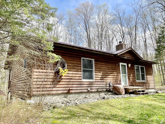 view of front of house featuring crawl space, metal roof, a chimney, and a front yard