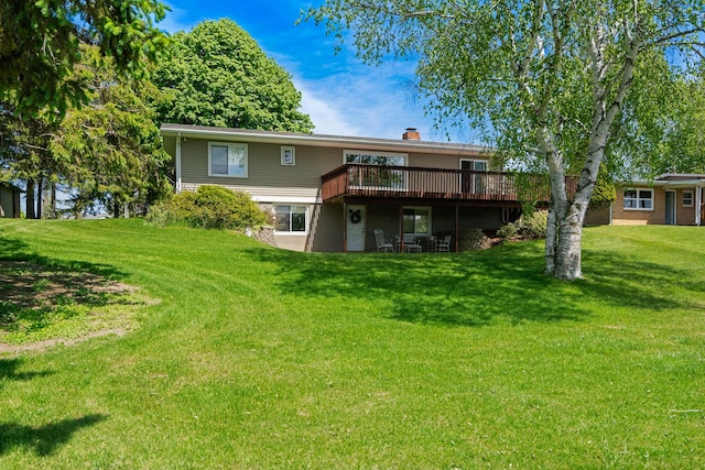 back of house with a yard, a deck, and a chimney