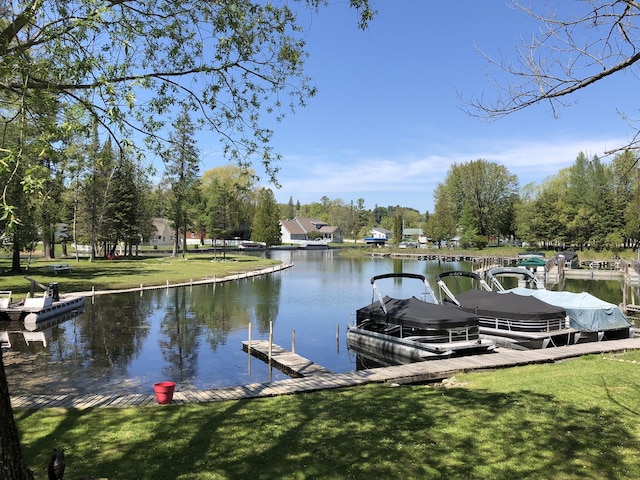 dock area featuring a lawn and a water view