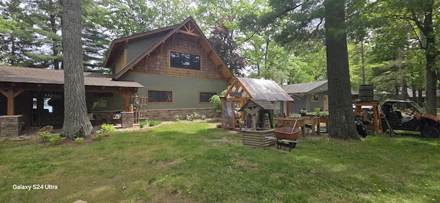 rear view of property featuring a lawn