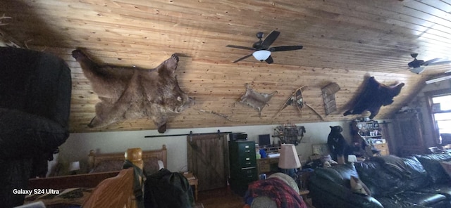 interior space with a barn door, wood ceiling, and a ceiling fan