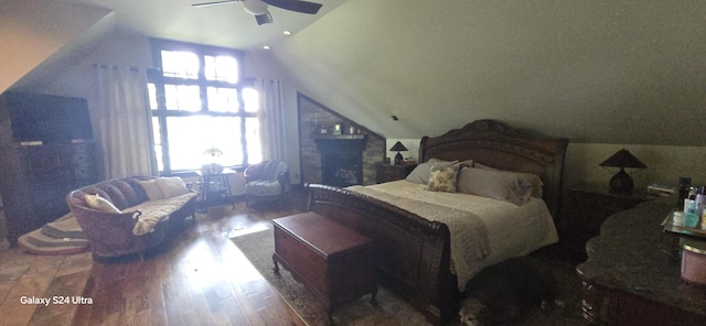 bedroom with ceiling fan, lofted ceiling, and wood finished floors