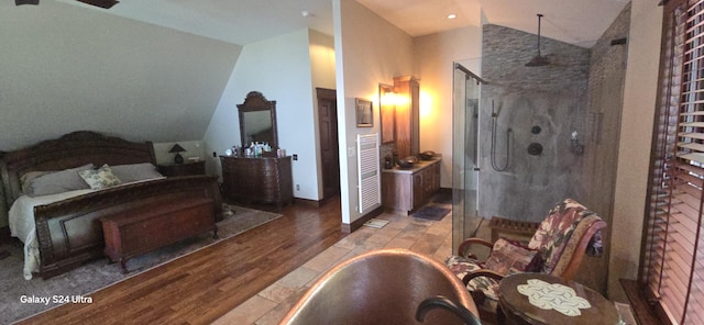 bathroom featuring a freestanding bath, a stall shower, wood finished floors, and vaulted ceiling