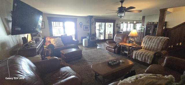 living area featuring a wood stove, plenty of natural light, and ceiling fan