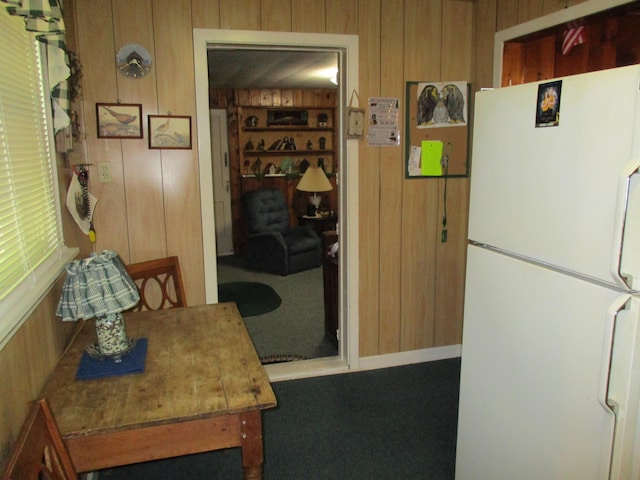 kitchen with wood walls and freestanding refrigerator