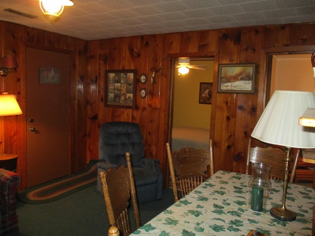 dining area with wooden walls and visible vents