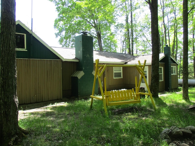 rear view of property featuring a chimney