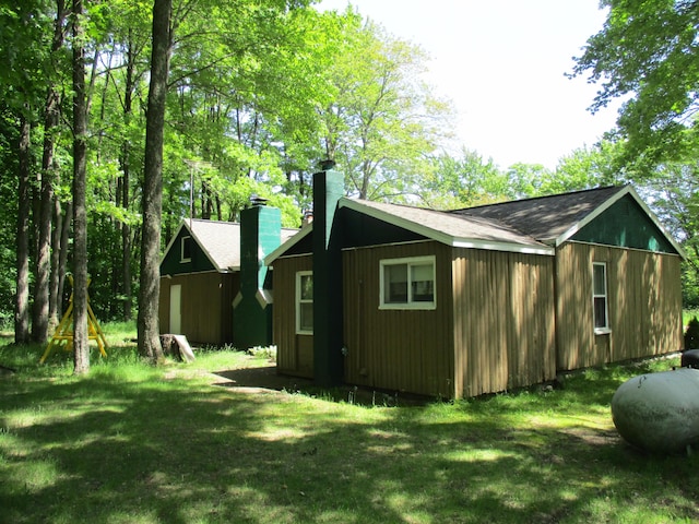 back of house with a lawn and a chimney