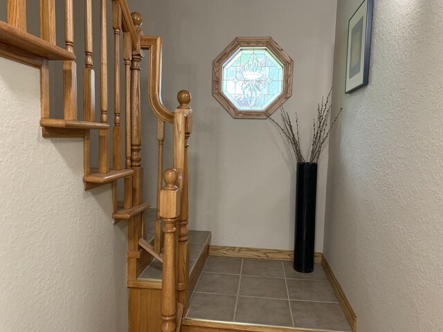 staircase with tile patterned floors and baseboards