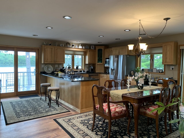 interior space with a wealth of natural light, an inviting chandelier, light wood-style flooring, and recessed lighting