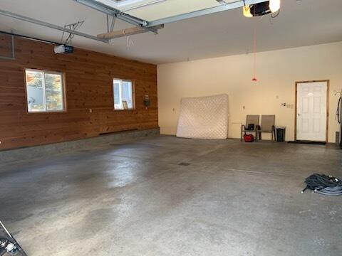 garage featuring wooden walls and a garage door opener