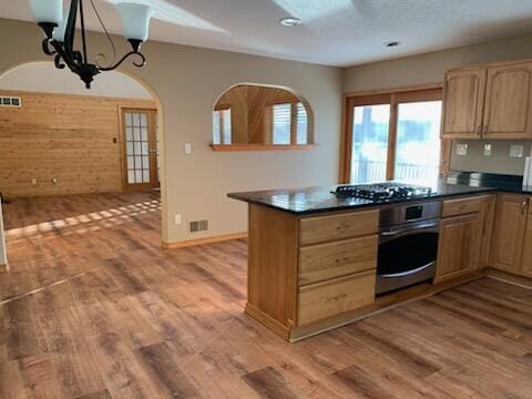 kitchen featuring dark countertops, visible vents, light wood-style flooring, and stainless steel appliances