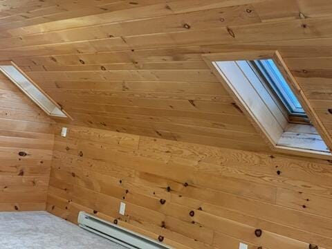 bonus room with wooden walls and a skylight