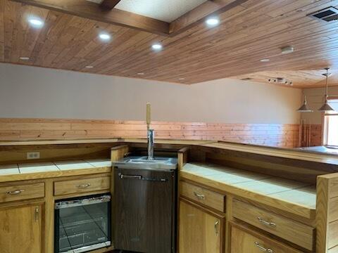 kitchen featuring tile countertops, visible vents, wooden ceiling, and recessed lighting