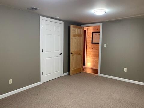 spare room with baseboards, carpet floors, and visible vents