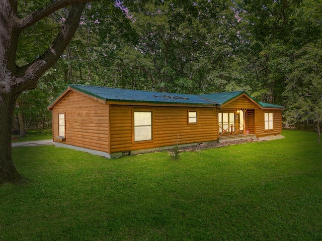 view of front of property featuring log veneer siding, metal roof, a front yard, and crawl space