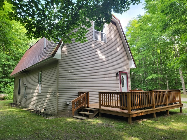 back of house featuring a deck, a lawn, a gambrel roof, and metal roof