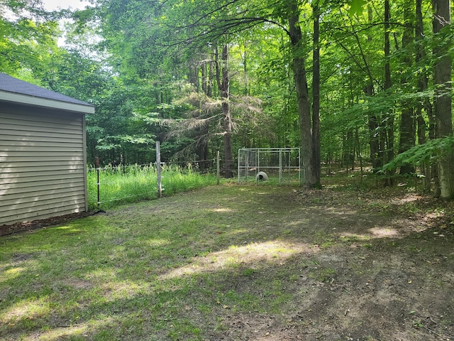 view of yard featuring a forest view and fence