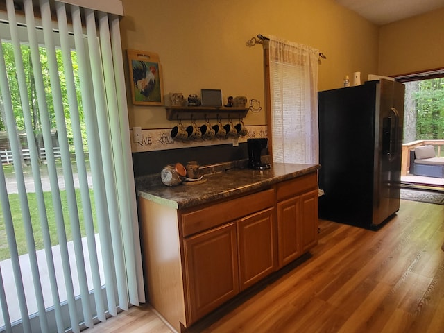 kitchen with fridge with ice dispenser and light wood finished floors