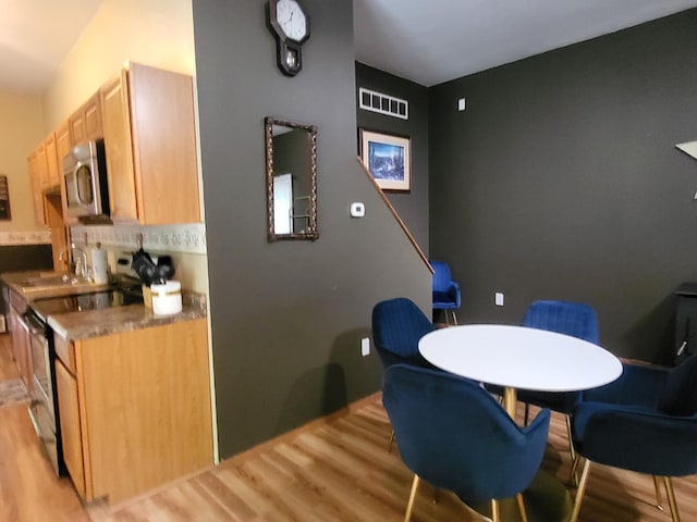 dining room with light wood-type flooring and visible vents