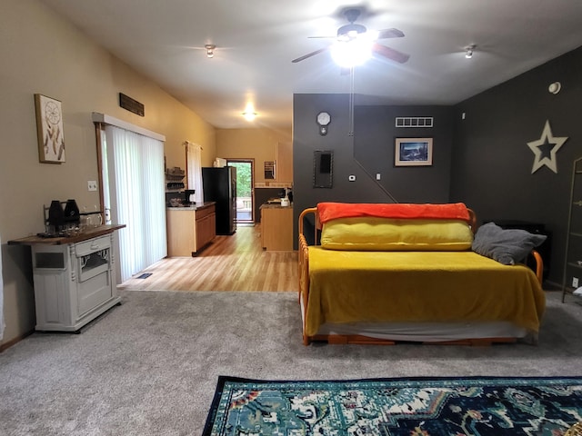 bedroom with visible vents, light colored carpet, ceiling fan, and freestanding refrigerator