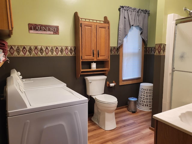 full bath with vanity, wood finished floors, a stall shower, toilet, and washing machine and dryer