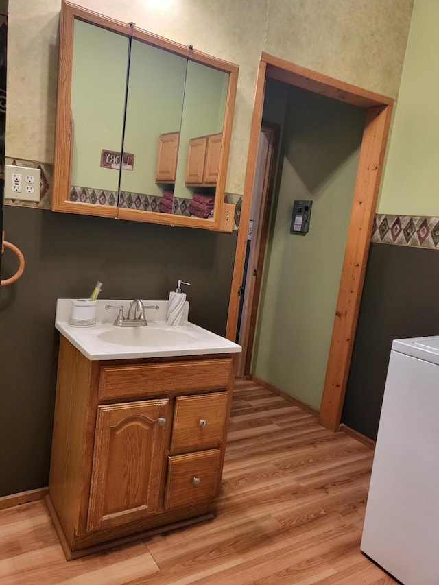 bathroom featuring vanity, washer / dryer, and wood finished floors