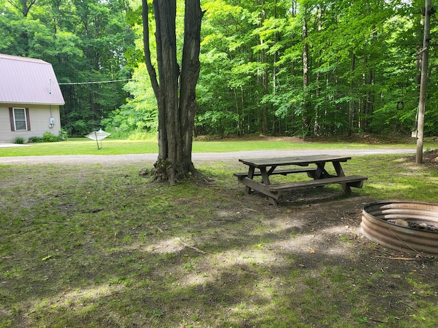 exterior space featuring a fire pit and a forest view