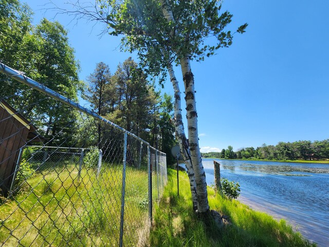 view of yard featuring fence and a water view