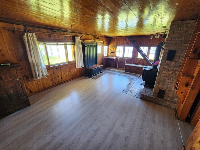 unfurnished living room with wood walls, wood ceiling, and wood finished floors