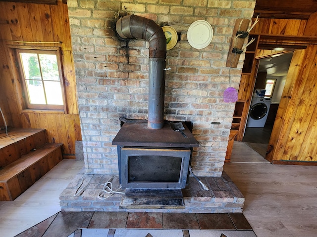 room details with washer / dryer, a wood stove, and wood finished floors