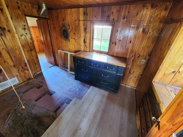 interior space with visible vents, wood finished floors, and wood walls