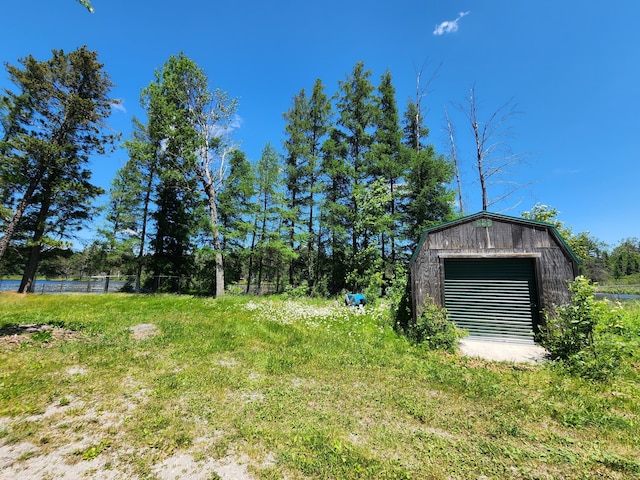 view of yard featuring a garage and an outdoor structure