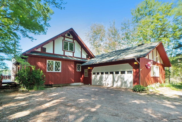 view of property exterior with an outbuilding, an attached garage, driveway, and a shingled roof