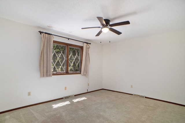spare room with carpet flooring, baseboards, visible vents, and ceiling fan