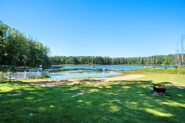 property view of water with a view of trees, fence, and an outdoor fire pit