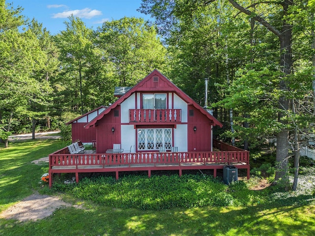 back of house featuring central air condition unit, a lawn, and a wooden deck