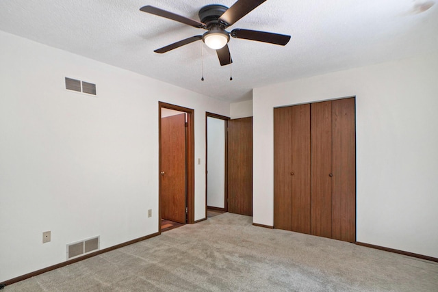 unfurnished bedroom with visible vents, carpet flooring, and a textured ceiling