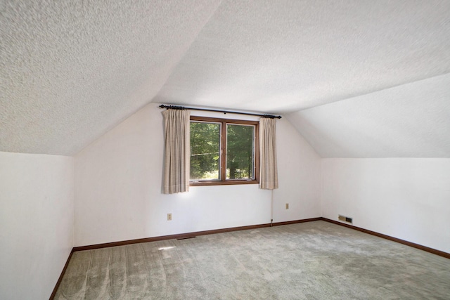 bonus room with visible vents, baseboards, carpet floors, vaulted ceiling, and a textured ceiling