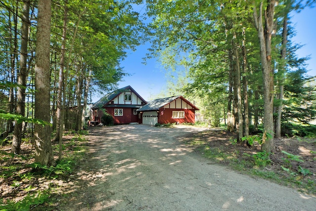 view of front of home featuring a garage and dirt driveway