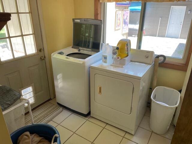 laundry area featuring light tile patterned flooring, laundry area, and washing machine and clothes dryer