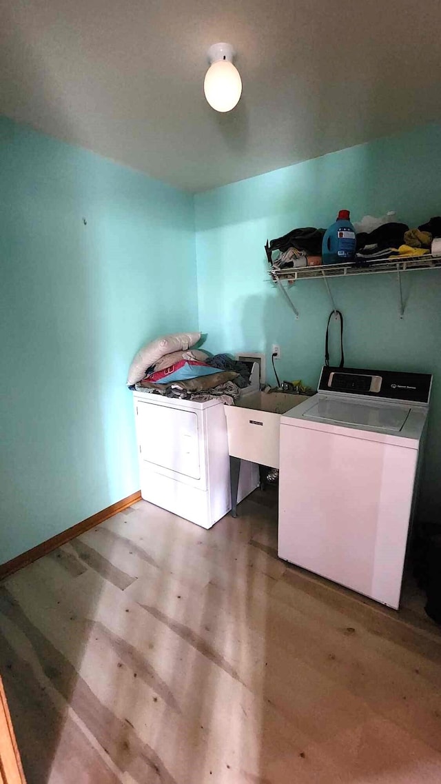 551 S US-23, Harrisville, MI 48740 - clothes washing area featuring laundry area, wood finished floors, baseboards, and washing machine and clothes dryer