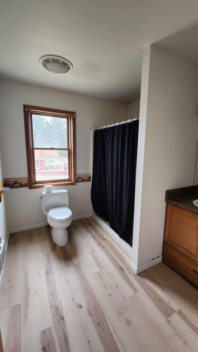 551 S US-23, Harrisville, MI 48740 - bathroom with a shower with curtain, wood finished floors, visible vents, baseboards, and toilet