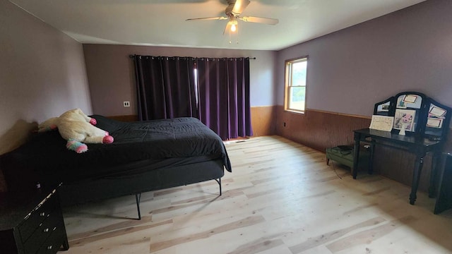 551 S US-23, Harrisville, MI 48740 - bedroom featuring a wainscoted wall, wood walls, ceiling fan, and wood finished floors
