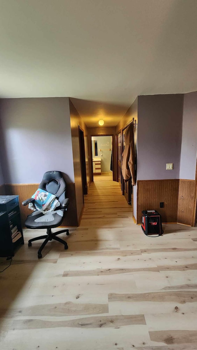 551 S US-23, Harrisville, MI 48740 - hallway with wooden walls, wainscoting, and light wood-style floors