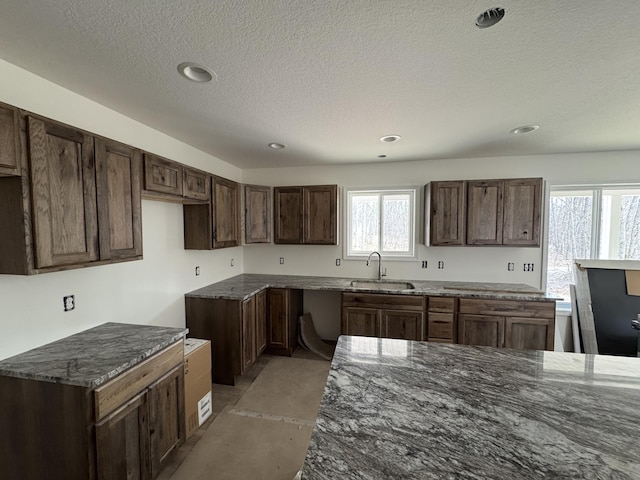 7805 Gray Hawk Ct, Gaylord, MI 49735 - kitchen featuring a sink, a textured ceiling, concrete floors, dark stone counters, and recessed lighting