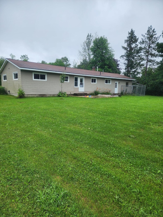 rear view of house featuring a yard